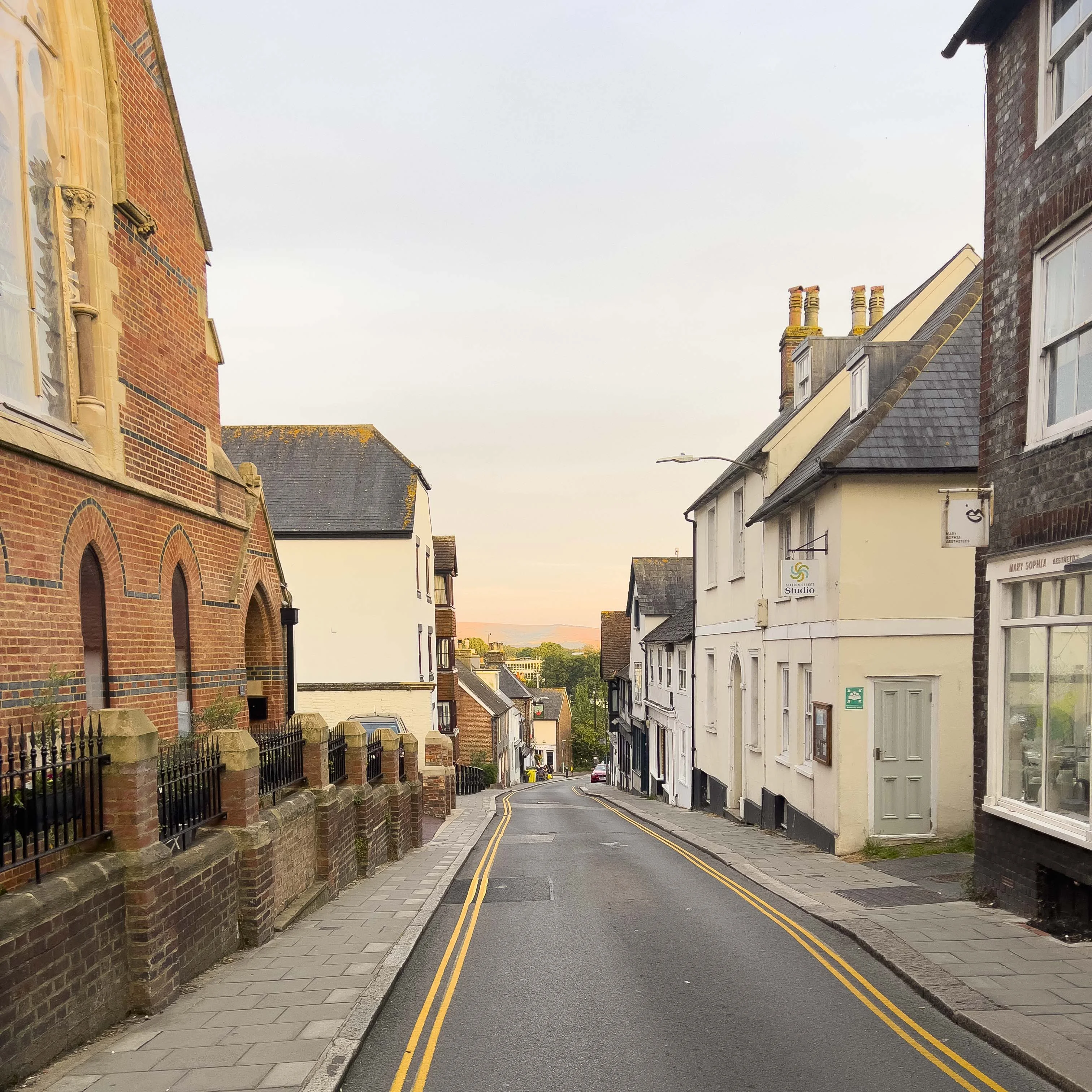 A calm English alleyway with soft sunset light.